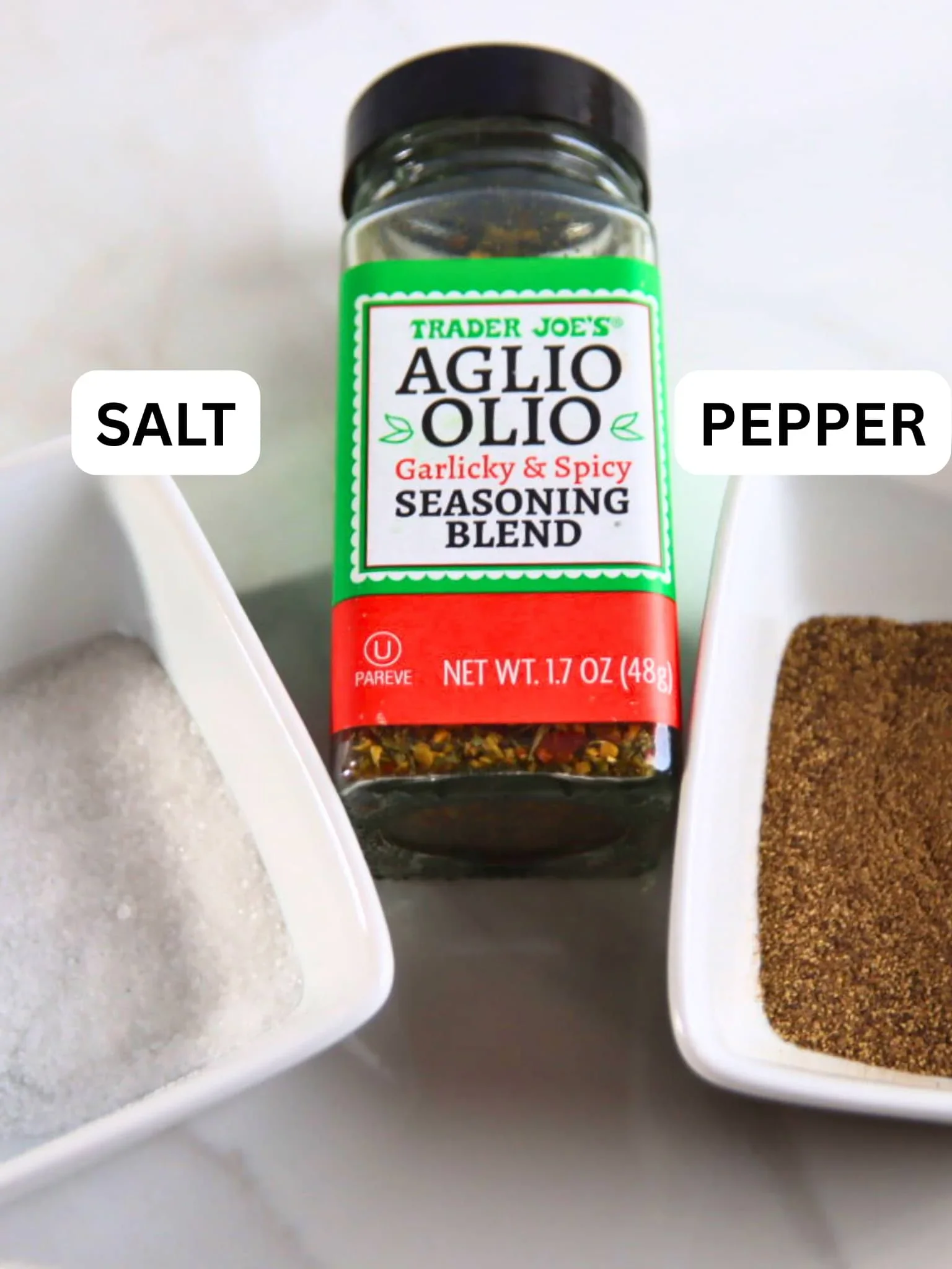 Salt, black pepper, and Trader Joe’s Aglio Olio garlic seasoning arranged for the fries.